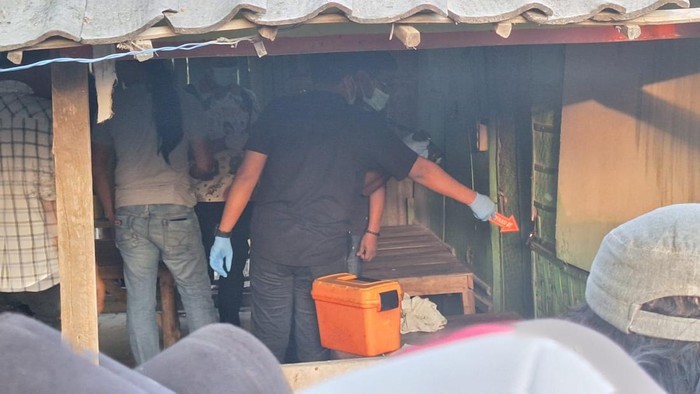 Polisi melakukan olah TKP di warung lokasi ditemukan dua mayat di Lamongan