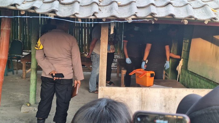 Polisi melakukan olah TKP di warung lokasi ditemukan dua mayat di Lamongan