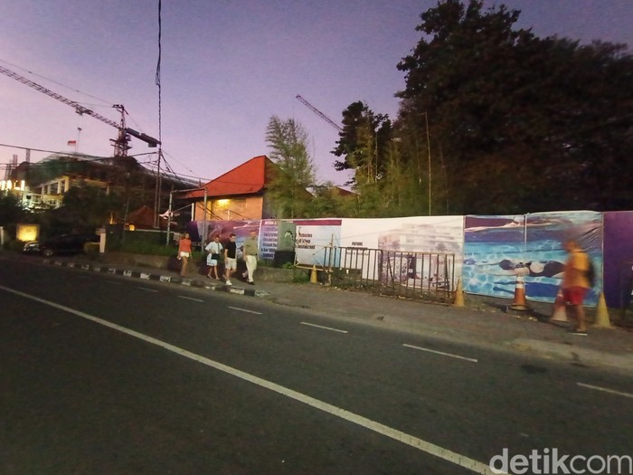 Sejumlah turis berjalan melewati lokasi pembangunan Sanur Beach Club di Jalan Danau Tamblingan, Sanur, Denpasar, Bali, Jumat (19/7/2024). (Ni Made Lastri Karsiani Putri/detikBali)