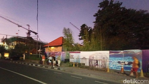 Sejumlah turis berjalan melewati lokasi pembangunan Sanur Beach Club di Jalan Danau Tamblingan, Sanur, Denpasar, Bali, Jumat (19/7/2024). (Ni Made Lastri Karsiani Putri/detikBali)