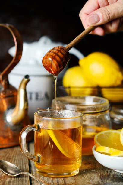 Lemon Tea with honey. Pouring tea from a teapot into a glass cup