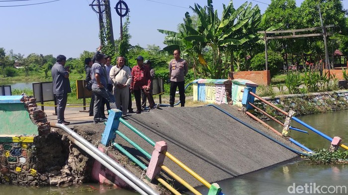 Warga bersama anggota Komisi C DPRD meninjau lokasi jembatan ambrol di Desa Kedungpeluk, Candi, Sidoarjo.
