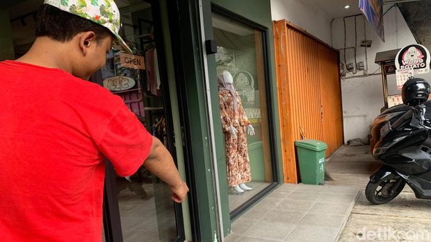 Warga menunjuk lokasi di mana tukang parkir tergeletak dan tak sadarkan diri usai berkelahi dengan tukang antar galon di Jaksel.