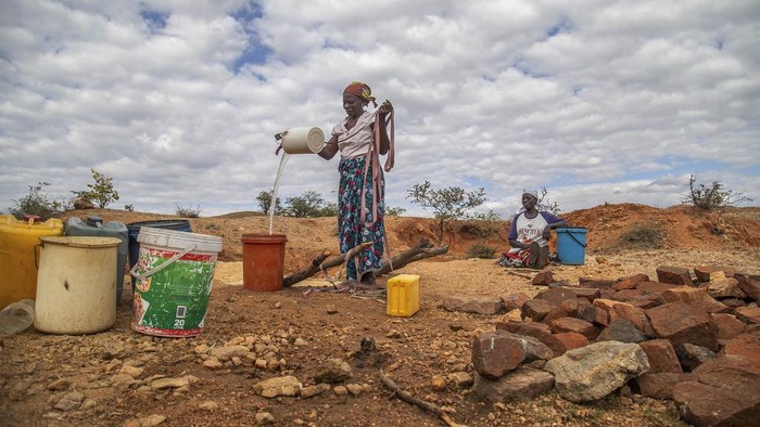 A man walks alongside a dried up stream in Mudzi, Zimbabwe, on July 2, 2024. In Zimbabwe, an El Nino-induced drought is affecting millions of people, and children are most at risk. (AP Photo/Aaron Ufumeli)