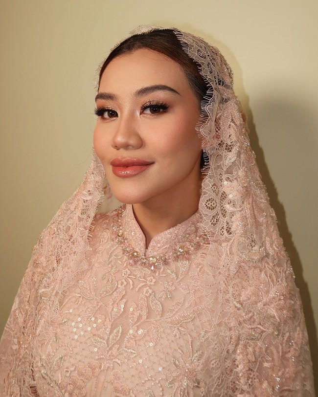 Untuk wajah, wanita 22 tahun tersebut mempercayakannya kepada Leo Afandi. Dalam foto yang diunggah sang makeup artist, Aal semakin cantik dengan riasan bernuansa peach. Foto: Instagram