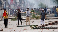 Seorang demonstran memberi isyarat ketika pengunjuk rasa bentrok dengan Penjaga Perbatasan Bangladesh (BGB) dan polisi di luar Bangladesh Television milik negara ketika kekerasan meletus di seluruh negeri setelah protes anti-kuota oleh mahasiswa, di Dhaka, Bangladesh, 19 Juli 2024.