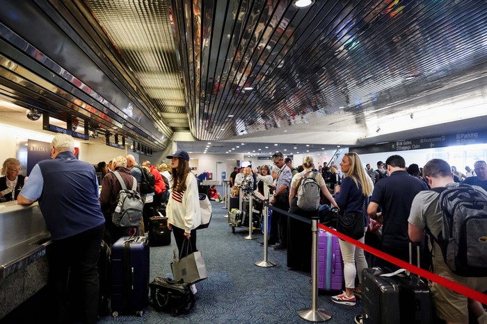 Passengers wait at Milwaukee Mitchell International Airport, after airlines grounded flights due to a worldwide tech outage caused by an update to CrowdStrikes 