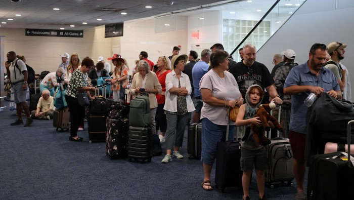Passengers wait at Milwaukee Mitchell International Airport, after airlines grounded flights due to a worldwide tech outage caused by an update to CrowdStrike's 