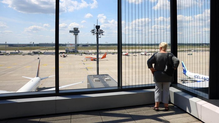 A lonely ground personel member walks on the tarmac of Berlin’s airport BER, as planes are parked following a global IT outage, in Berlin, Germany, July, 19, 2024. REUTERS/Nadja Wohlleben     TPX IMAGES OF THE DAY