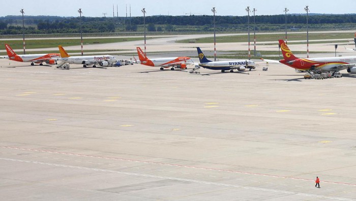A lonely ground personel member walks on the tarmac of Berlin’s airport BER, as planes are parked following a global IT outage, in Berlin, Germany, July, 19, 2024. REUTERS/Nadja Wohlleben     TPX IMAGES OF THE DAY