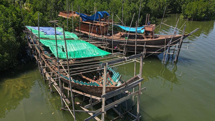 Foto udara pekerja menyelesaikan pembuatan kapal nelayan secara tradisional di Kelurahan Bungkutoko, Kendari, Sulawesi Tenggara, Sabtu (20/7/2024). Pembuatan kapal dengan volume 40 gross ton tersebut memakan waktu antara 5-7 bulan tergantung ketersediaan bahan baku dengan biaya kerja sebesar Rp300 juta. ANTARA FOTO/Andry Denisah/aww.