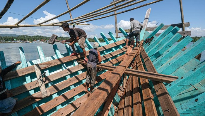 Foto udara pekerja menyelesaikan pembuatan kapal nelayan secara tradisional di Kelurahan Bungkutoko, Kendari, Sulawesi Tenggara, Sabtu (20/7/2024). Pembuatan kapal dengan volume 40 gross ton tersebut memakan waktu antara 5-7 bulan tergantung ketersediaan bahan baku dengan biaya kerja sebesar Rp300 juta. ANTARA FOTO/Andry Denisah/aww.