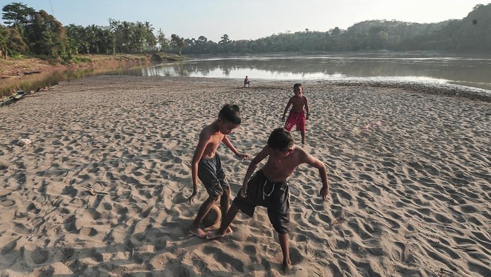 Penyusutan debit air Sungai Batanghari Sejumlah anak bermain sepak bola di tepi Sungai Batanghari yang surut di Desa Olak, Batanghari, Jambi, Sabtu (20/7/2024). Menurut warga, debit air sungai terpanjang di Sumatera yang melewati desa itu menyusut hingga sejauh 50 meter dalam sepekan terakhir dan dimanfaatkan sebagian warga untuk tempat bermain. ANTARA FOTO/Wahdi Septiawan.