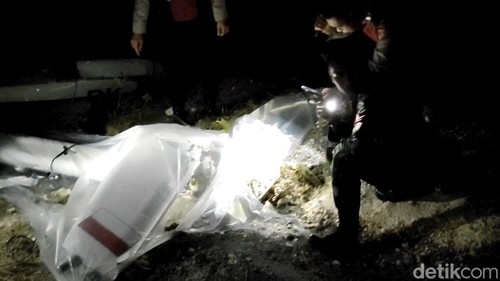 Puing helikopter yang jatuh di Pecatu, Kuta Selatan, Badung, Bali, dijaga aparat, Jumat (19/7/2024) malam.