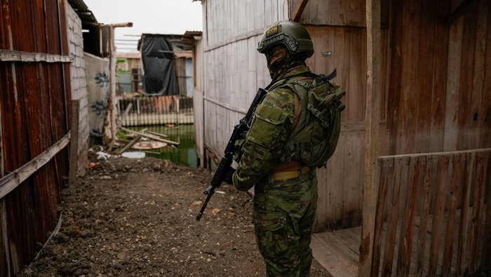 A soldier searches for members of drug gangs, hidden weapons or drugs during a government operation to return homes, allegedly stolen by drug gangs, to their rightful owners, in Duran, Ecuador July 19, 2024. REUTERS/Santiago Arcos