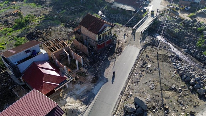 Warga Bangun Kembali Rumah yang Terdampak Lahar Dingin Gunung Marapi Foto udara warga membangun kembali rumahnya yang hancur akibat terdampak banjir lahar dingin Gunung Marapi di Simpang Bukik, Nagari Bukik Batabuah, Agam, Sumatera Barat, Sabtu (20/7/2024). Data pemerintah nagari setempat menunjukkan terdapat sedikitnya 45 kepala keluarga yang rumahnya berada di zona merah terdampak bencana pada 11 Mei 2024 lalu, tapi warga mengaku masih belum mendapat kejelasan dari pemerintah kabupaten untuk relokasi termasuk jaminan kesejahteraan mereka dari aspek ekonomi, sosial, dan pendidikan. ANTARA FOTO/Iggoy el Fitra/aww.