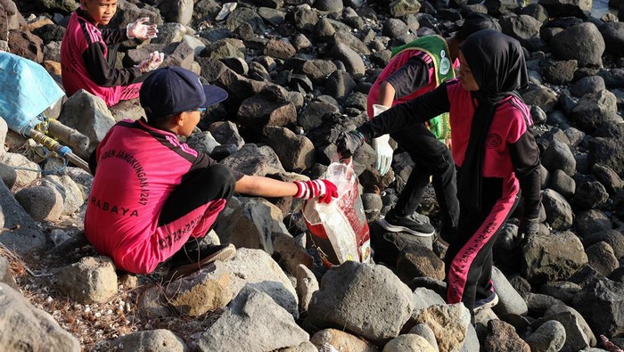 Aksi Pelajar Bersih-bersih Sampah di Pantai Kenjeran Surabaya Seorang pelajar memungut sampah di Pantai Kenjeran, Surabaya, Jawa Timur, Minggu (21/7/2024). Aksi bersih-bersih pantai yang dilakukan sejumlah pelajar didampingi orang tuanya dan komunitas Tunas Hijau itu merupakan wujud kepedulian terhadap kebersihan lingkungan khususnya di lokasi wisata kawasan pesisir. ANTARA FOTO/Didik Suhartono/wpa.