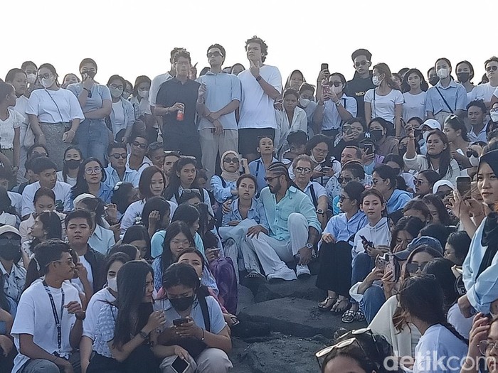 Jennifer Coppen bersama keluarga dan fans duduk di Pantai Lembeng, Desa Lembeng, Kecamatan Sukawati, Gianyar, saat prosesi pelarungan abu Yitta Dali Wassink, Minggu (21/7/2024). (Ni Made Lastri Karsiani Putri/detikBali)
