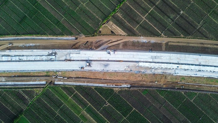 Melihat Progres Pembangunan Tol Probolinggo-Banyuwangi Foto udara Jalan Tol Probolinggo - Banyuwangi seksi 1 Gending - Kraksan di Kabupaten Probolinggo, Jawa Timur, Minggu (21/7/2024). Berdasarkan data Badan Pengatur Jalan Tol (BPJT) Kementerian PUPR per Rabu (17/7), progres penyelesaian Tol Probolinggo - Banyuwangi untuk tahap 1 Gending - Besuki yang terbagi menjadi 3 Seksi yakni Seksi 1 Gending - Kraksaan sepanjang 12,88 Km dengan progres konstruksi 60,08 persen, Seksi 2 Kraksaan - Paiton sepanjang 11,20 Km dengan progres konstruksi 40,40 persen, dan Seksi 3 Paiton - Besuki 25,6 Km dengan progres konstruksi 31,38 persen. ANTARA FOTO/Irfan Sumanjaya/foc.