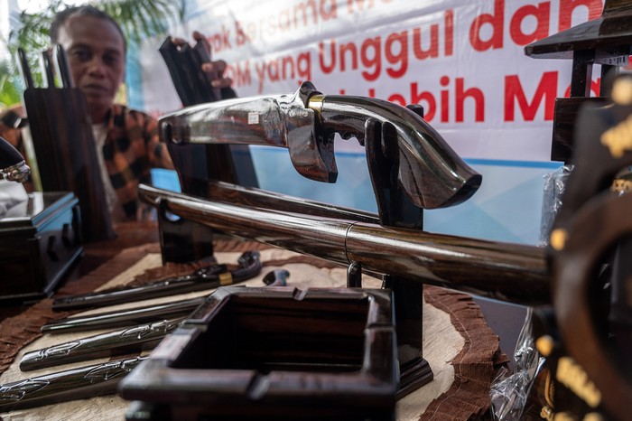 Perajin asal Kabupaten Poso menata berbagai produk kerajinan yang  terbuat dari kayu hitam atau ebony (Diospyros celebica Bakh) yang dipamerkan di Palu, Sulawesi Tengah, Minggu (21/7/2024). Pameran produk kerajinan berbahan kayu yang diinisiasi oleh Dinas Perindustrian dan Perdagangan setempat dan diikuti seluruh kabupaten se Sulteng itu dimaksudkan untuk mengenalkan sekaligus membuka jalur pemasaran bagi produk kerajinan kayu khas setiap daerah. ANTARA FOTO/Basri Marzuki/foc.