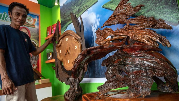 Perajin asal Kabupaten Poso menata berbagai produk kerajinan yang  terbuat dari kayu hitam atau ebony (Diospyros celebica Bakh) yang dipamerkan di Palu, Sulawesi Tengah, Minggu (21/7/2024). Pameran produk kerajinan berbahan kayu yang diinisiasi oleh Dinas Perindustrian dan Perdagangan setempat dan diikuti seluruh kabupaten se Sulteng itu dimaksudkan untuk mengenalkan sekaligus membuka jalur pemasaran bagi produk kerajinan kayu khas setiap daerah. ANTARA FOTO/Basri Marzuki/foc.