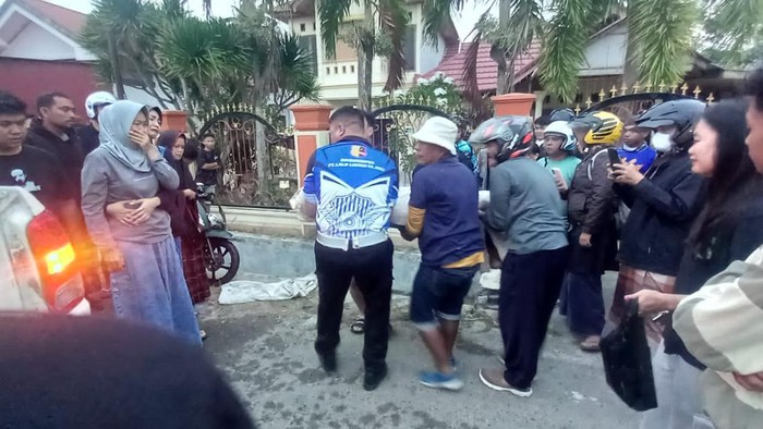 Polisi dan warga mengevakuasi jasad korban kecelakaan motor di Gorontalo.