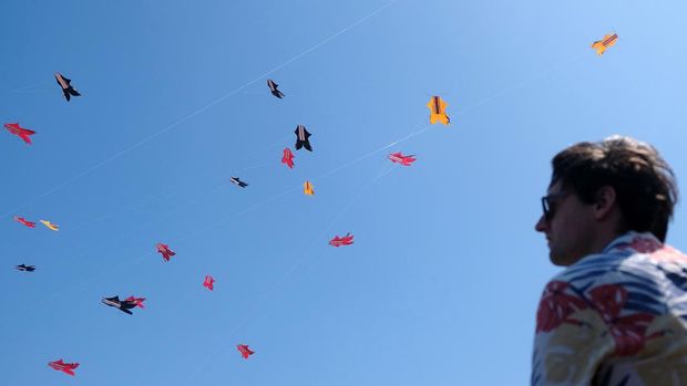 Sejumlah peserta berusaha menangkap layang-layang tradisional Bali yang diturunkan saat mengikuti perlombaan pada Festival Layangan Piala Gubernur Bali 2024 di Pantai Padanggalak, Denpasar, Bali, Minggu (21/7/2024). Kegiatan yang diselenggarakan oleh Komunitas Seni Layanan Bali bekerja sama dengan Pemerintah Provinsi Bali tersebut diikuti 1.340 peserta  untuk pelestarian permainan tradisional Bali. ANTARA FOTO/Nyoman Hendra Wibowo/wpa.