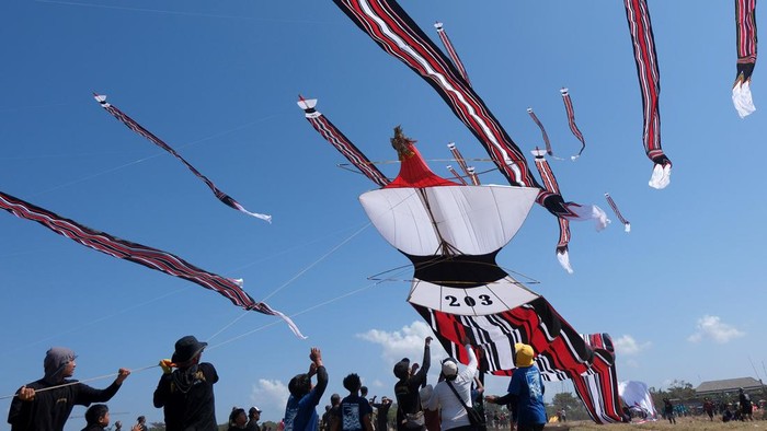 Sejumlah peserta berusaha menangkap layang-layang tradisional Bali yang diturunkan saat mengikuti perlombaan pada Festival Layangan Piala Gubernur Bali 2024 di Pantai Padanggalak, Denpasar, Bali, Minggu (21/7/2024). Kegiatan yang diselenggarakan oleh Komunitas Seni Layanan Bali bekerja sama dengan Pemerintah Provinsi Bali tersebut diikuti 1.340 peserta  untuk pelestarian permainan tradisional Bali. ANTARA FOTO/Nyoman Hendra Wibowo/wpa.