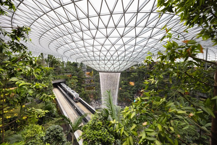 Singapore - January 7, 2024: Singapore Jewel Changi Airport. The Singapore Jewel Rain Vortex is the largest indoor waterfall in the world located inside the Jewal Changi Airport in Singapore. Singapore Airport Monorail train driving through the huge Jewel Changi.