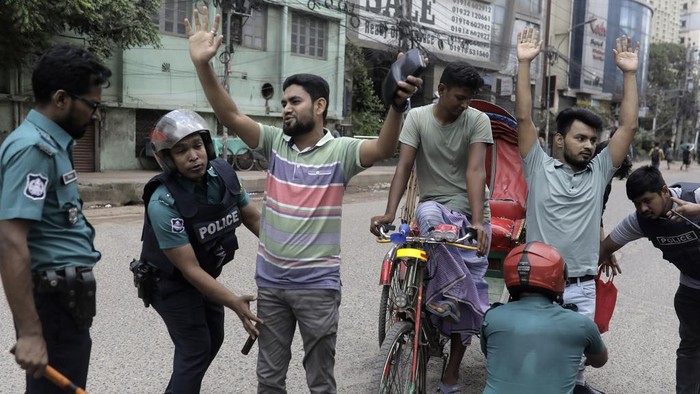 Bangladesh Terapkan Jam Malam Saat Demo Tolak Kuota PNS Memanas Police officers frisk commuters during a curfew imposed after scores were killed and hundreds injured in clashes over the allocation of civil service jobs, in Dhaka, Bangladesh, Sunday July 21, 2024. Bangladesh's top court on Sunday scaled back a controversial quota system for government job applicants, a partial victory for student protesters after days of nationwide unrest and deadly clashes between police and demonstrators that have killed scores of people. (AP Photo/Anik Rahman)