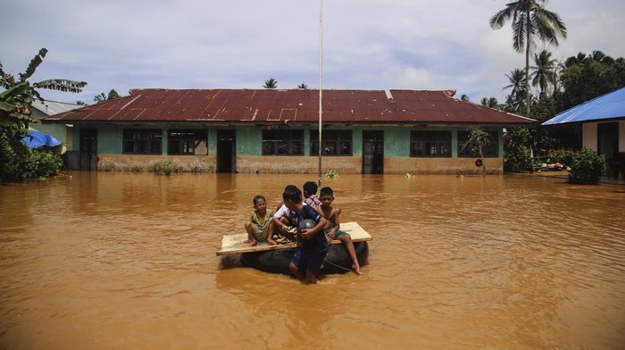 Sejumlah anak bermain menggunakan pelampung dari ban bekas saat banjir di Desa Lukulamo, Kabupaten Halmahera Tengah, Maluku Utara, Senin (22/7/2024). Banjir yang terjadi sejak Minggu (21/7) akibat hujan deras itu menyebabkan Sungai Kobe meluap sehingga sebanyak empat desa terendam yaitu Desa Lukulamo, Lelilef Woebulan, Woekob dan Desa Woejerana. ANTARAFOTO/Andri Saputra/nym.