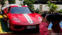 Salah satu mobil mewah yang disita adalah Ferrari warna merah dengan nomor polisi B 1985 SHM.  