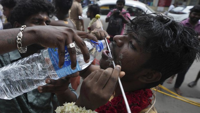 Hindu devotees with their cheeks pierced with steel rods participate in 'Aadi' festival in Chennai, India, Sunday, July 21, 2024. 'Aadi' is considered a holy month by Tamils and is observed with prayers and offerings to Hindu goddess. (AP Photo/Mahesh Kumar A.)