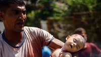 Seorang pria Palestina bereaksi sambil memegang jenazah anaknya yang tewas dalam serangan Israel, di rumah sakit Nasser, di Khan Younis di selatan Jalur Gaza 22 Juli 2024.  