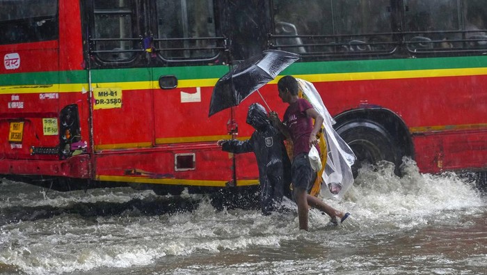 Sejumlah pengendara menerobos banjir yang merendam jalanan di Mumbai, Inida, Minggu (21/7/2024).