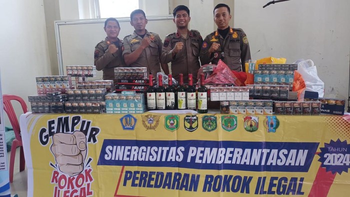 Satpol PP Palopo menunjukkan rokok dan miras ilegal yang diamankan bersama Bea Cukai.