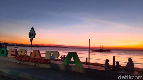 Sejumlah pengunjung sedang menikmati sunset di Pantai Oesapa, Kecamatan Kelapa Lima, Kota Kupang, NTT, Minggu (14/7/2024). (Yufengki Bria/detikBali).