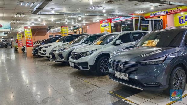 Seorang pengunjung melihat mobil-mobil bekas yang dijual di Mangga Dua Square pada Senin (22/7/2024). (CNBC Indonesia/Martyasari Rizky)