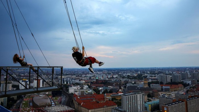 Uji Adrenalin Naik Ayunan Tertinggi di Eropa, Berani? A person swings 120m over ground near Alexanderplatz on the highest swing in Europe which allow participants, secured via a bungee line, to swing as far out as they dare, in Berlin, Germany July 21, 2024. REUTERS/Nadja Wohlleben TPX IMAGES OF THE DAY
