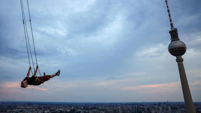 A person swings 120m over ground near Alexanderplatz on the highest swing in Europe which allow participants, secured via a bungee line, to swing as far out as they dare, in Berlin, Germany July 21, 2024. REUTERS/Nadja Wohlleben     TPX IMAGES OF THE DAY