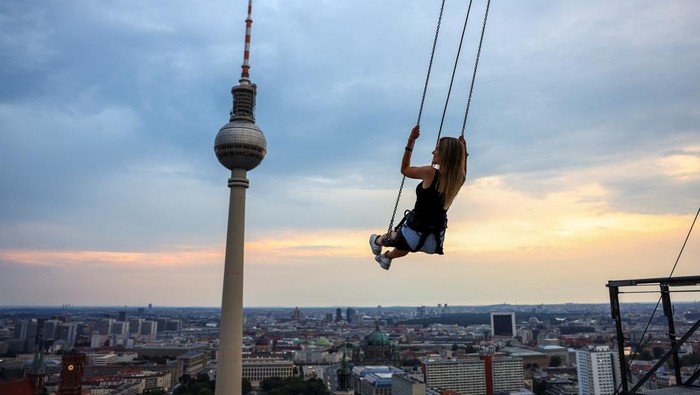 Uji Adrenalin Naik Ayunan Tertinggi di Eropa, Berani? A person swings 120m over ground near Alexanderplatz on the highest swing in Europe which allow participants, secured via a bungee line, to swing as far out as they dare, in Berlin, Germany July 21, 2024. REUTERS/Nadja Wohlleben TPX IMAGES OF THE DAY
