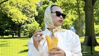 Liburan ke New York, Amerika Serikat, Wanda Hara sempatkan berkeliling di taman. Momennya semakin lengkap sambil memegang mangga potong nan segar. Foto: Instagram wanda_haraa