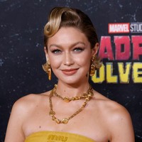 Gigi Hadid memakai busana terinspirasi dari Wolverine, yang identik dengan kostum kuning-hitam. Model berdarah Palestina ini memilih busana dari MiuMiu, berupa strapless bandana sebagai atasan yang dipadukan dengan rok midi berwarna senada. Foto: Getty Images