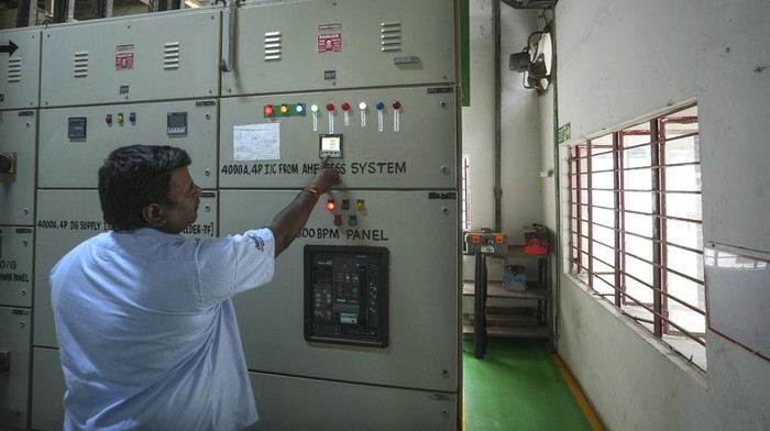 Ini Lho Baterai Raksasa untuk Operasional Pabrik di India A worker walks in front of the 500 KW Battery Energy storage system inside the Hindustan Coca-Cola Beverages factory in Thiruvallur district, on the outskirts of Chennai, India, Tuesday, July16, 2024. (AP Photo/Mahesh Kumar A.)