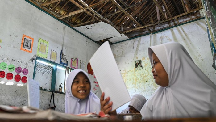 Kasihan Siswa-siswi Ini Belajar dalam Kondisi Sekolah Rusak Seorang siswa menanti jam belajar di ruangan kelas yang rusak di MIS Al-Khaeriyah, Cisoka, Kabupaten Tangerang, Banten, Selasa (23/7/2024). Sekolah gratis yang mengampu 93 siswa dengan empat ruang kelas tersebut mengalami kerusakan di bagian atap sejak empat tahun lalu dan membutuhkan bantuan renovasi agar tidak membahayakan siswa saat mengikuti kegiatan belajar. ANTARA FOTO/Sulthony Hasanuddin/tom.