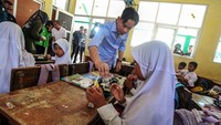 Gibran membagikan makanan dan memastikan anak-anak menyantapnya.  