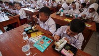Para siswa makan secara bersama-sama dengan disaksikan oleh Gibran.  