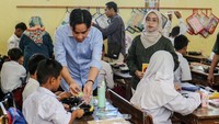 Gibran membagikan sendiri makanan untuk anak-anak sekolah tersebut.