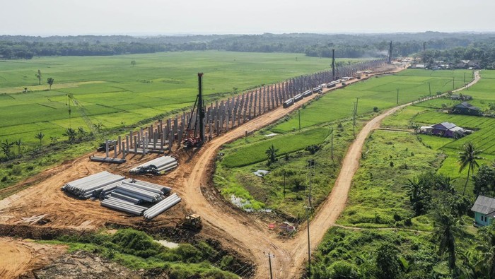 Foto udara pembangunan proyek Jalan Tol Serang-Panimbang di Pandeglang, Banten, Selasa (23/7/2024). Progres pembangunan Jalan Tol Serang-Panimbang seksi III fase I Cileles-Panimbang dengan panjang 83,67 km telah mencapai lebih dari 50 persen dan ditargetkan selesai pada akhir tahun 2024, pembangunan jalan tol tersebut guna mendukung akses menuju kawasan pariwisata di Banten yang dapat mempersingkat waktu tempuh dari Jakarta menuju kawasan pantai di Banten dari empat jam menjadi 2,5 jam. ANTARA FOTO/Galih Pradipta/tom.