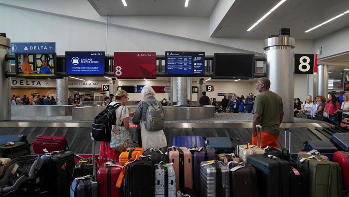 People speak to Delta agents as they try to rebook their travel plans after long delays following cyber outages affecting airlines at Hartsfield-Jackson Atlanta International Airport in Atlanta, Georgia, U.S., July 22, 2024.   REUTERS/Megan Varner